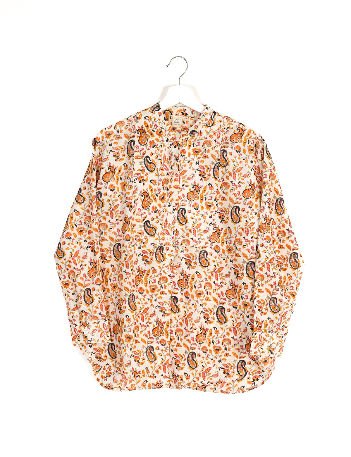 Longline white shirt with orange and black paisley floral print, button front, and band collar, hanging on white hanger