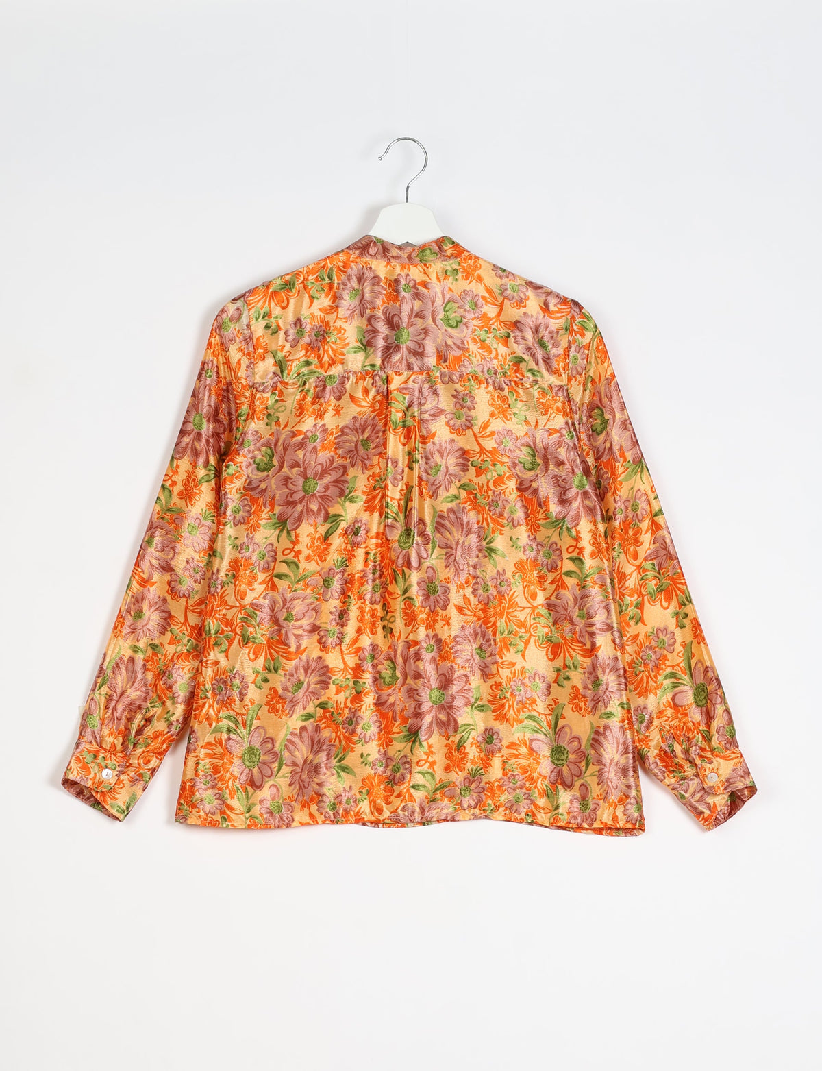 Yellow floral blouse with long sleeves and buttoned cuffs, shown from the back on a white hanger