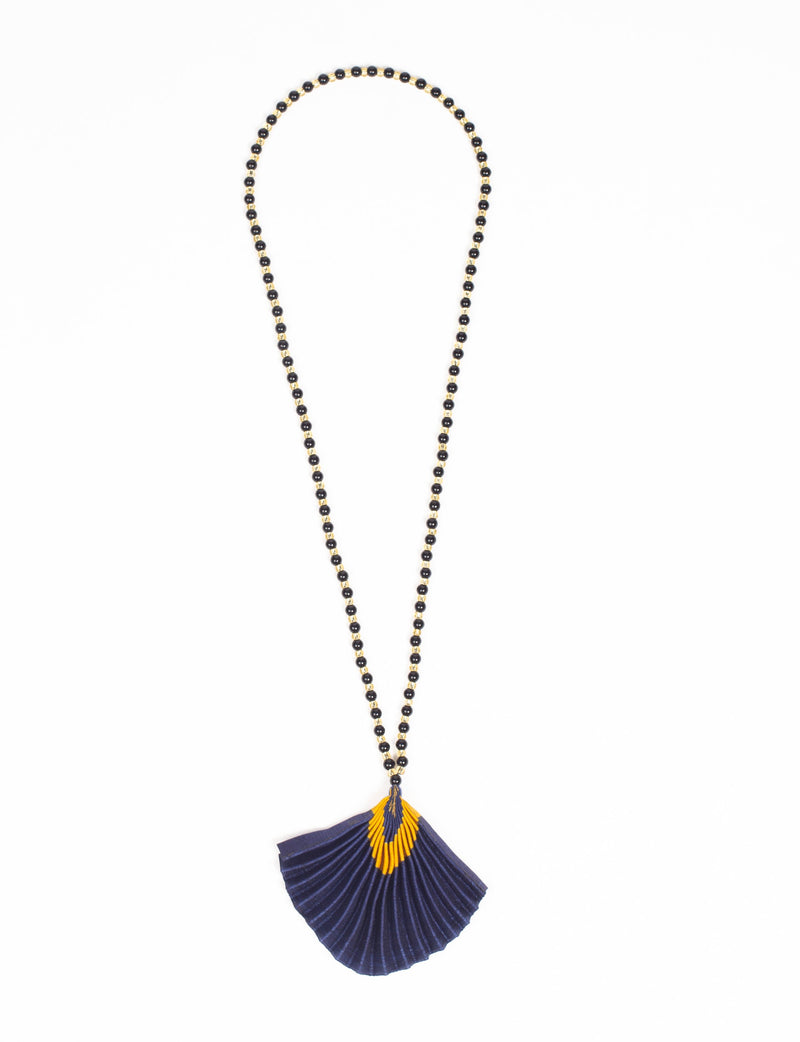 Long necklace with alternating black and gold beads and a pleated blue fabric pendant with a yellow abstract pattern