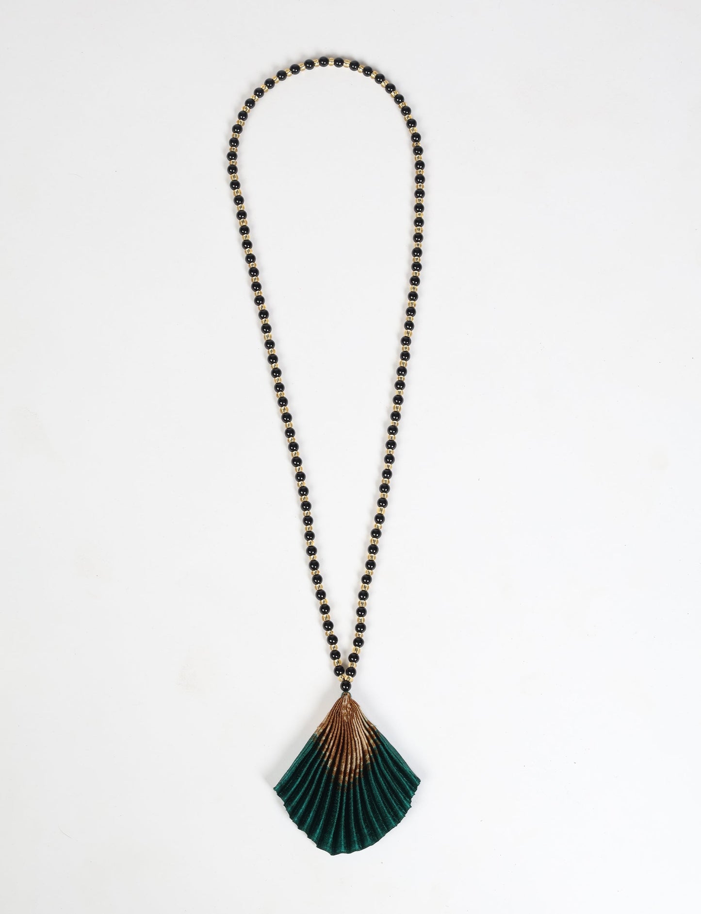 Dive into sustainable fashion with our PLEATED NECKLACE, a creation by talented female artisans in Mumbai. The pleated fan pendant, made from upcycled saris, hangs on a colorful necklace crafted from glass beads, embellished with sparkling glass crystals. An ethical, green fashion statement for conscious styling.