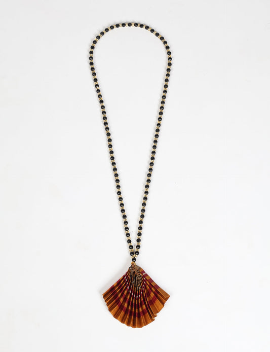 Dive into sustainable fashion with our PLEATED NECKLACE, a creation by talented female artisans in Mumbai. The pleated fan pendant, made from upcycled saris, hangs on a colorful necklace crafted from glass beads, embellished with sparkling glass crystals. An ethical, green fashion statement for conscious styling.