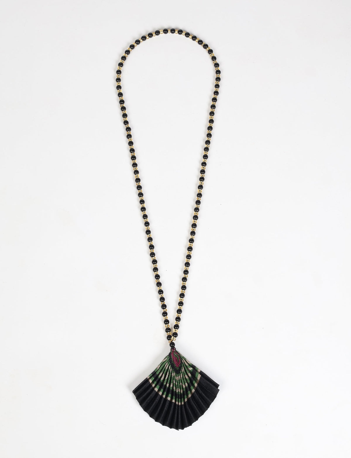 Necklace with black and gold beads and a pleated fan-shaped pendant in black, green, and purple, flat lay on white background