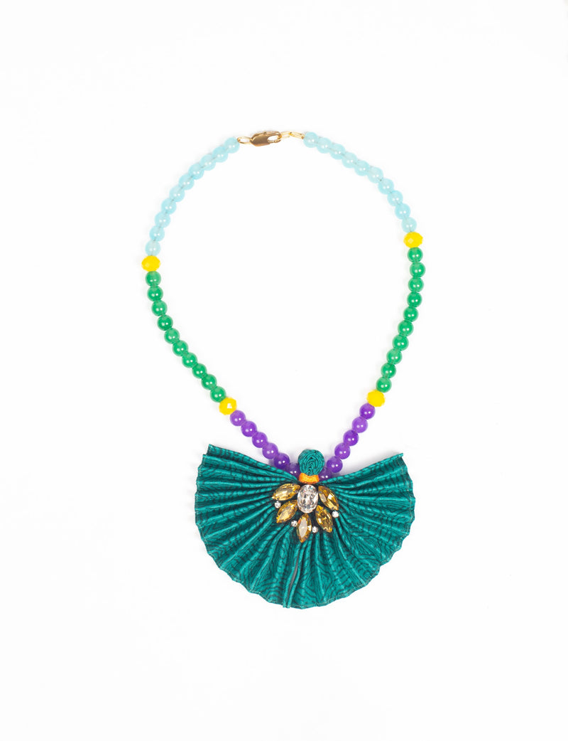 Beaded necklace with light blue, green, purple, and yellow beads, featuring a pleated green fabric pendant with gem embellishments