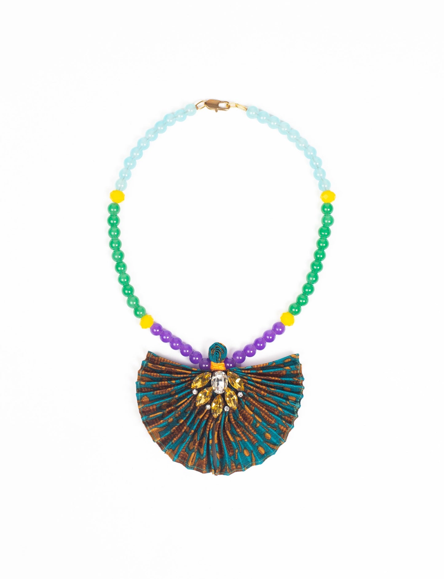 Dive into sustainable fashion with our PLEATED NECKLACE, a creation by talented female artisans in Mumbai. The pleated fan pendant, made from upcycled saris, hangs on a colorful necklace crafted from glass beads, embellished with sparkling glass crystals. An ethical, green fashion statement for conscious styling.