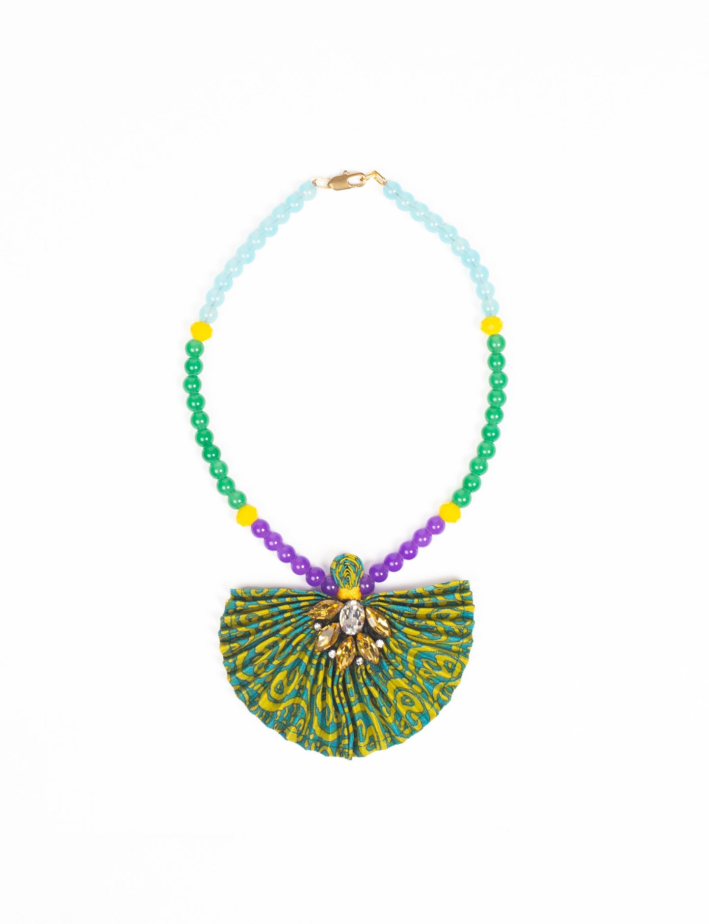 Dive into sustainable fashion with our PLEATED NECKLACE, a creation by talented female artisans in Mumbai. The pleated fan pendant, made from upcycled saris, hangs on a colorful necklace crafted from glass beads, embellished with sparkling glass crystals. An ethical, green fashion statement for conscious styling.