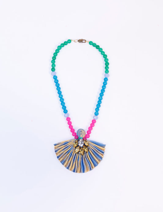 Dive into sustainable fashion with our PLEATED NECKLACE, a creation by talented female artisans in Mumbai. The pleated fan pendant, made from upcycled saris, hangs on a colorful necklace crafted from glass beads, embellished with sparkling glass crystals. An ethical, green fashion statement for conscious styling.