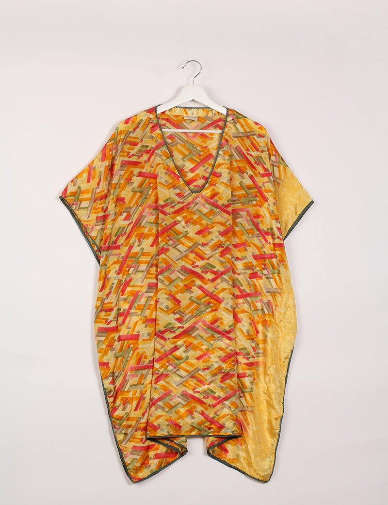 Yellow kaftan with abstract multicolor geometric pattern, deep V-neck, lace trim, hanging on white hanger, front view