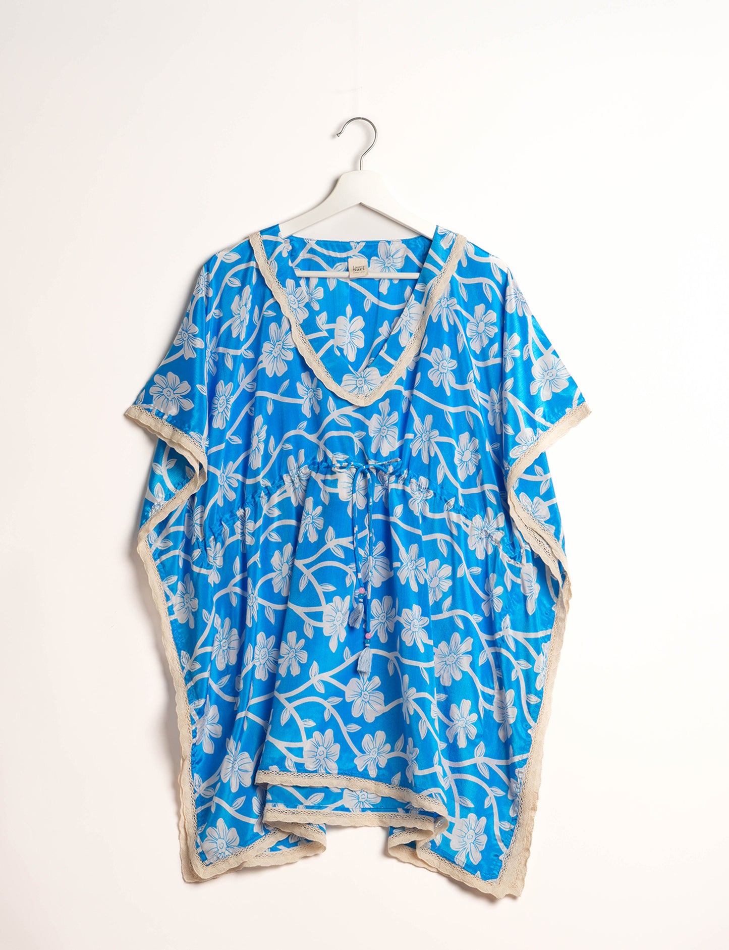 Elevate your style with our short kaftan, a perfect blend of ethical and green fashion. The light and loose-flowing fabric, drawstring waist, beaded tassel ends, and delicate lace edging make it a versatile choice for urban summers, beachwear, or poolside elegance. Enjoy sustainable and fashionable living.