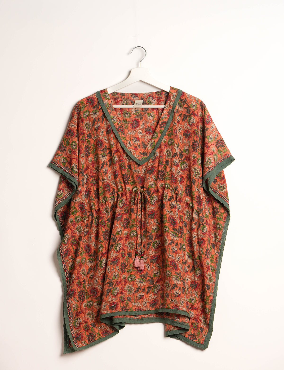Elevate your style with our short kaftan, a perfect blend of ethical and green fashion. The light and loose-flowing fabric, drawstring waist, beaded tassel ends, and delicate lace edging make it a versatile choice for urban summers, beachwear, or poolside elegance. Enjoy sustainable and fashionable living.