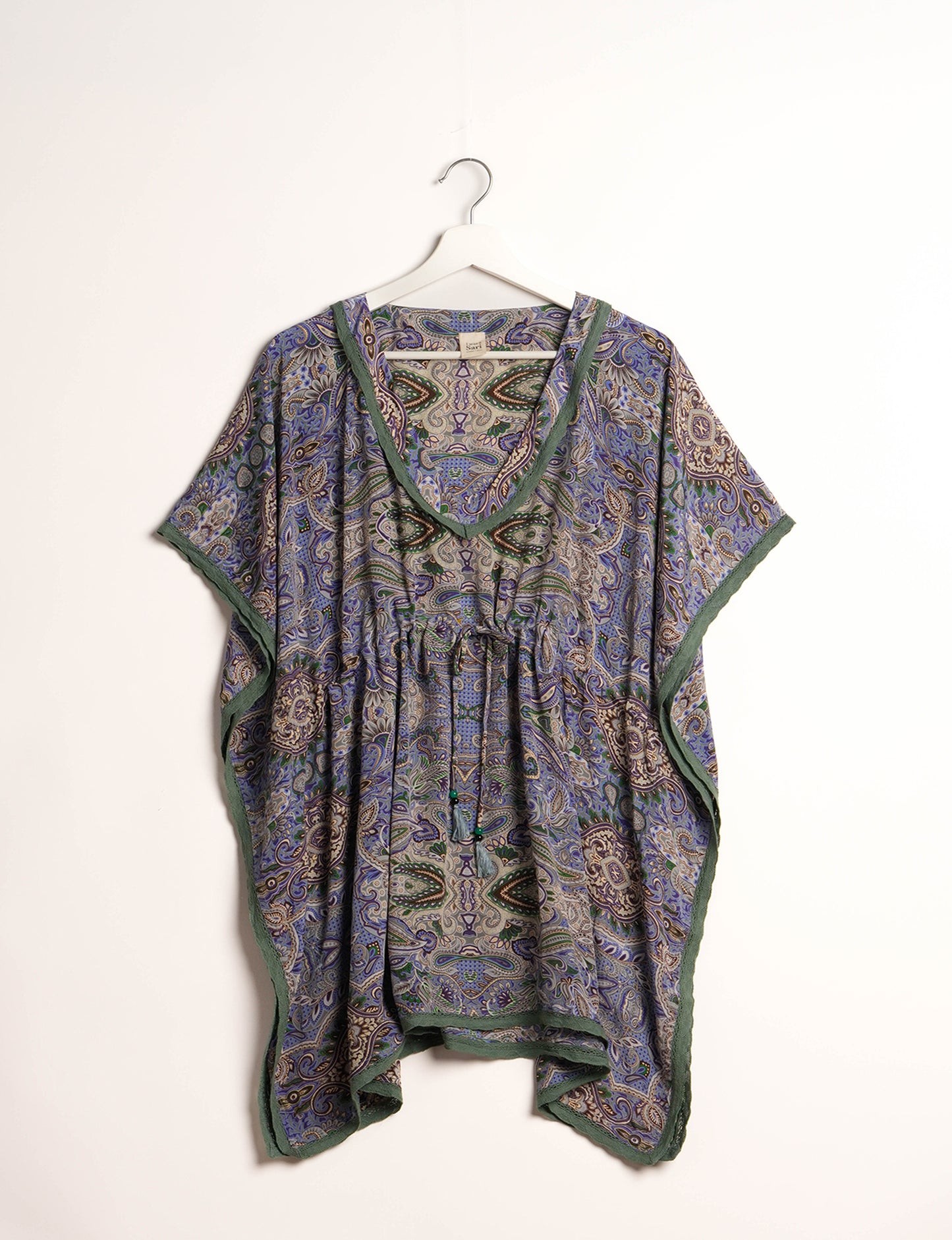 Elevate your style with our short kaftan, a perfect blend of ethical and green fashion. The light and loose-flowing fabric, drawstring waist, beaded tassel ends, and delicate lace edging make it a versatile choice for urban summers, beachwear, or poolside elegance. Enjoy sustainable and fashionable living.