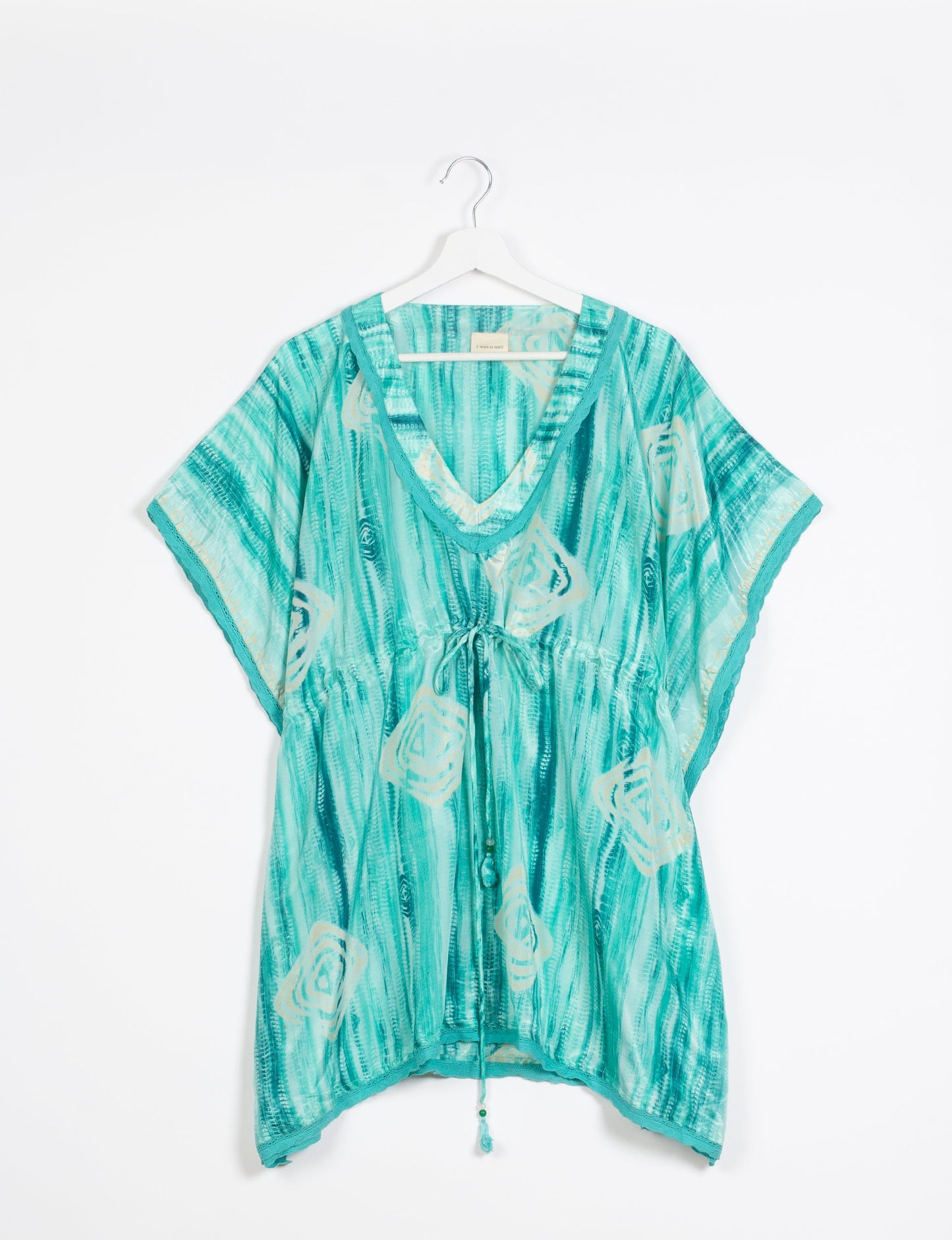 Elevate your style with our short kaftan, a perfect blend of ethical and green fashion. The light and loose-flowing fabric, drawstring waist, beaded tassel ends, and delicate lace edging make it a versatile choice for urban summers, beachwear, or poolside elegance. Enjoy sustainable and fashionable living.