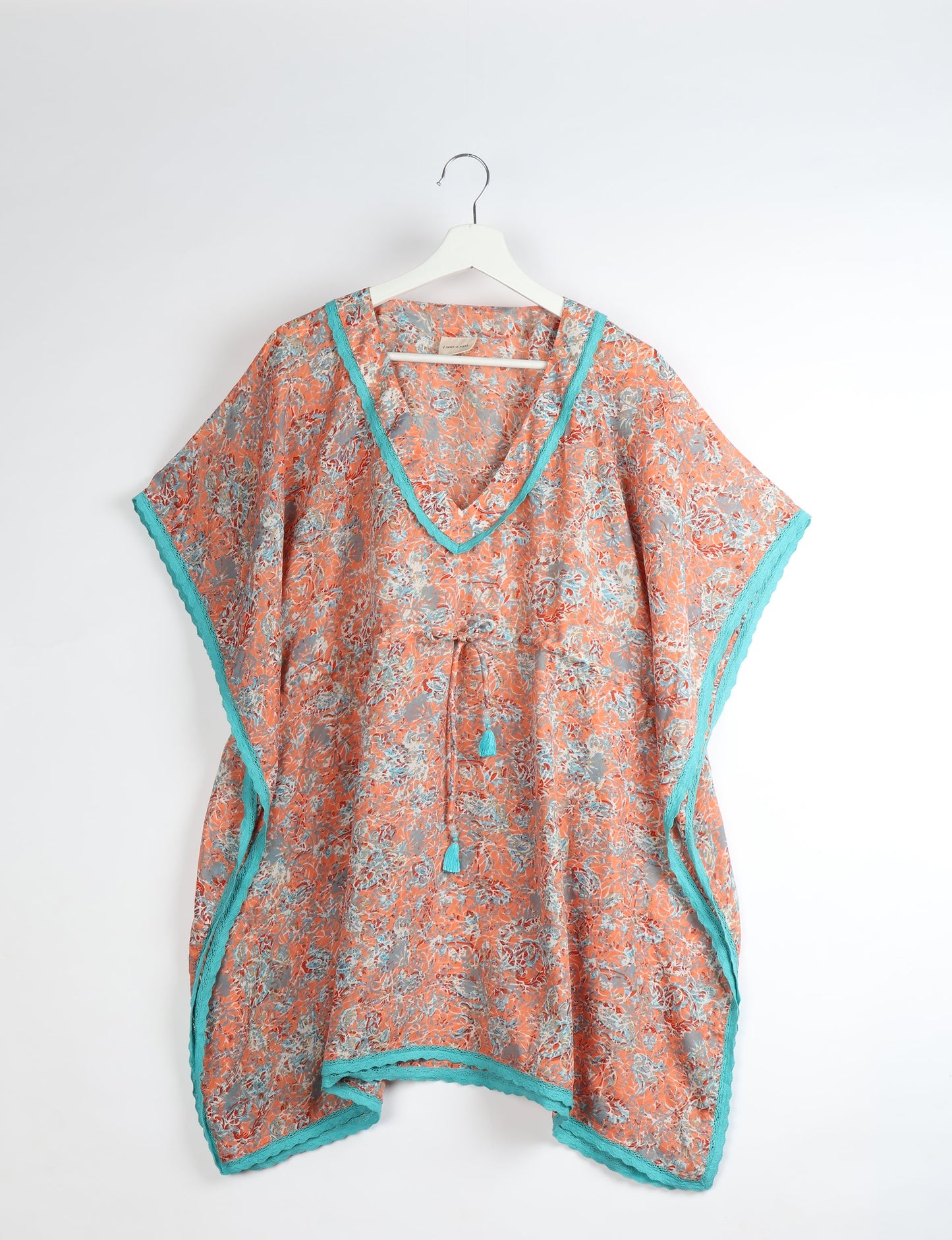 Elevate your style with our short kaftan, a perfect blend of ethical and green fashion. The light and loose-flowing fabric, drawstring waist, beaded tassel ends, and delicate lace edging make it a versatile choice for urban summers, beachwear, or poolside elegance. Enjoy sustainable and fashionable living.