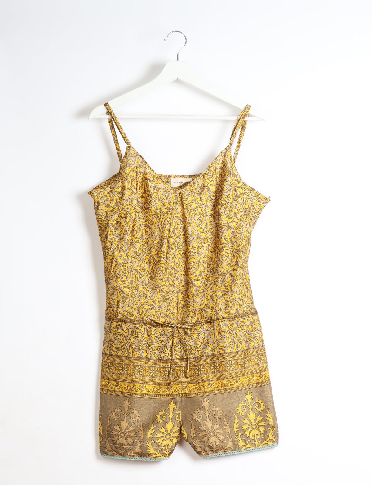 Yellow floral patterned playsuit with adjustable spaghetti straps, lace trim at hem, and drawstring waist, hanging on white