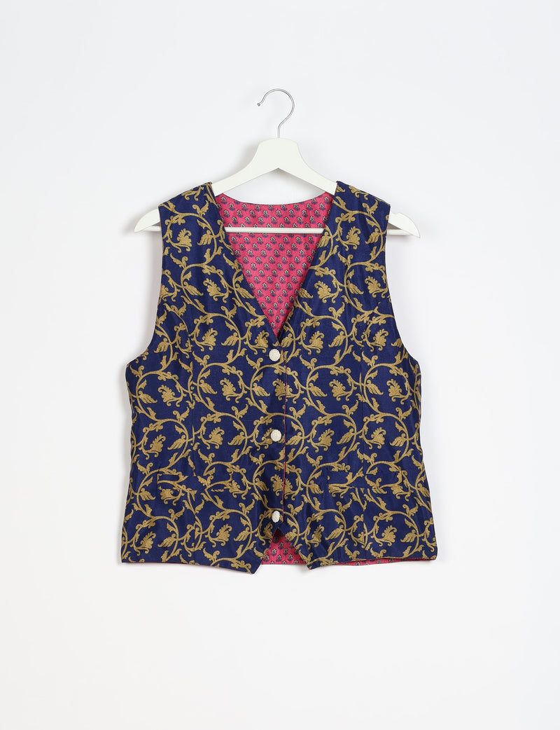 Blue waistcoat with gold floral vine pattern, front button closure, and pink floral inner lining, hanging on white hanger
