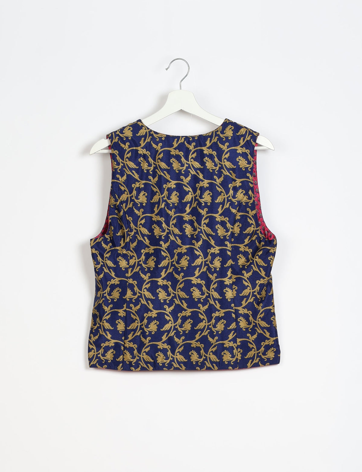 Blue sleeveless waistcoat with gold floral vine pattern, round neckline, shown from back on white hanger against white background
