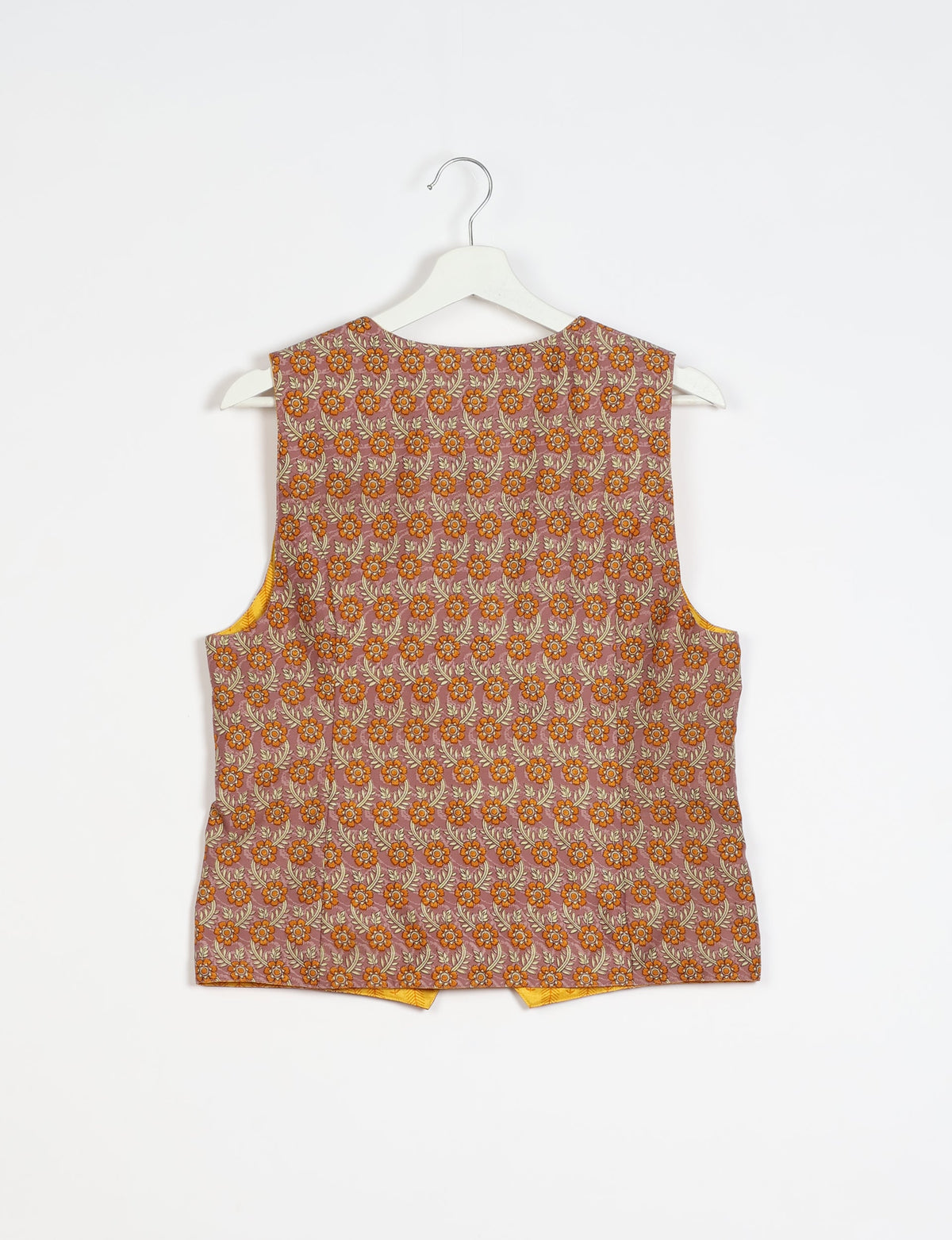 Brown floral patterned sleeveless waistcoat hanging on a white hanger against a white background