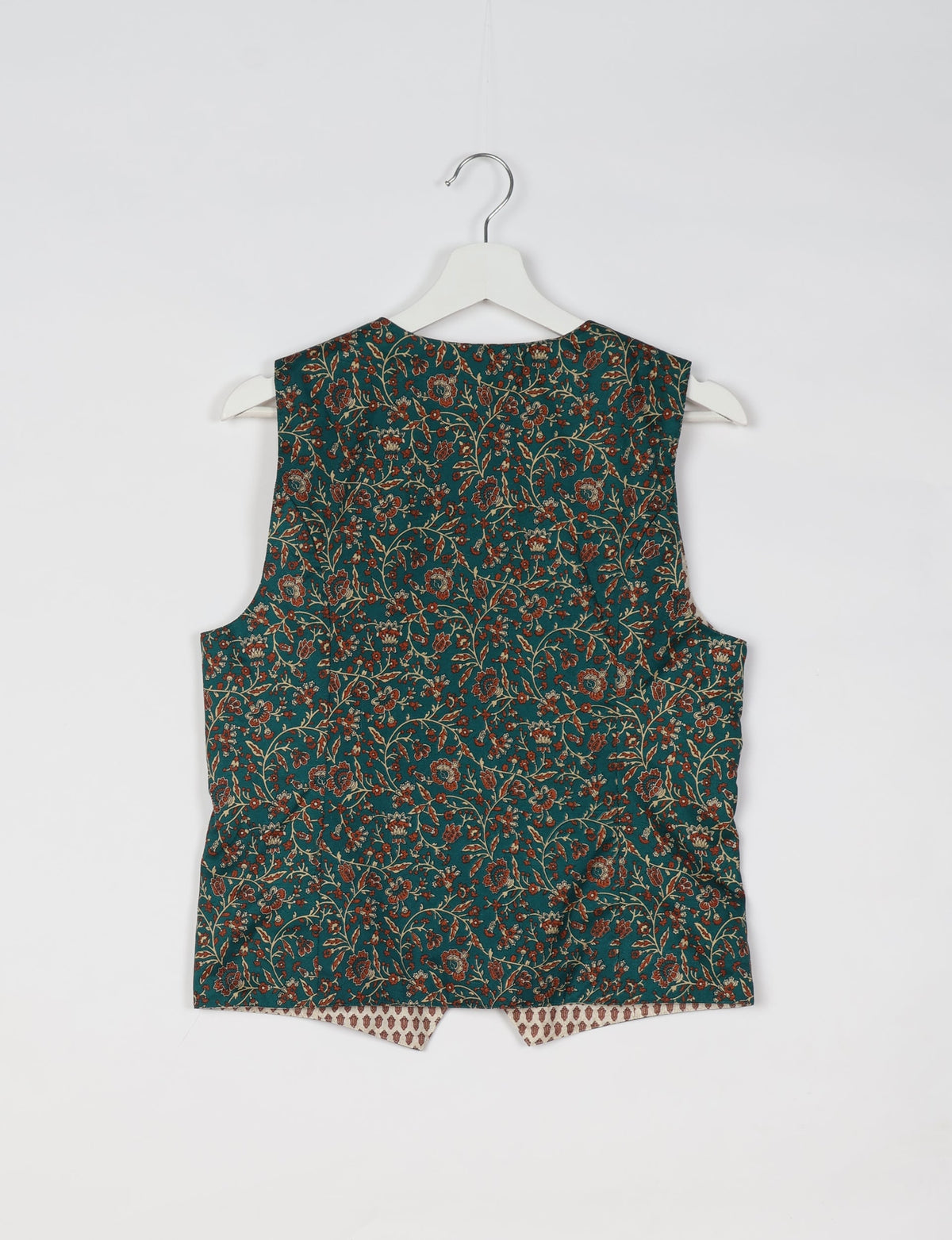 Green sleeveless waistcoat with red and beige floral micro design, shown from back on white hanger against white background