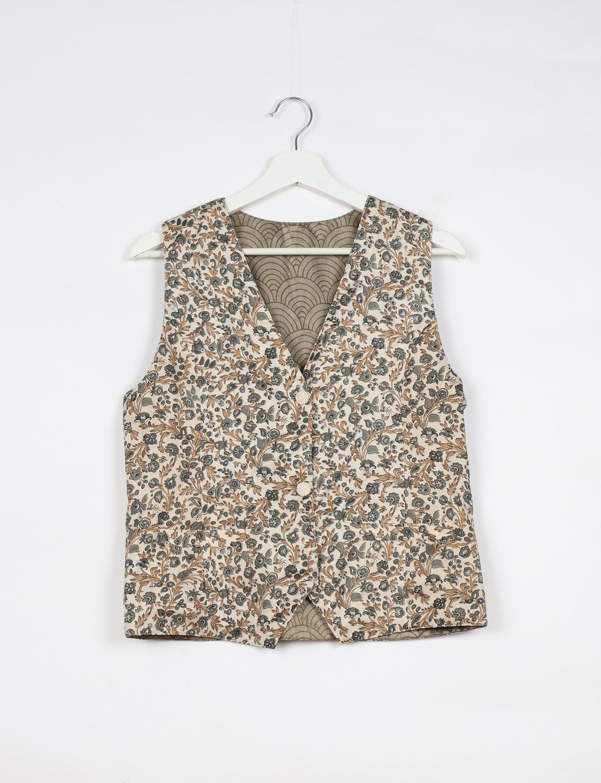 White waistcoat with brown and gray floral print, button front, V-neck, and patterned inner lining, hanging on white hanger