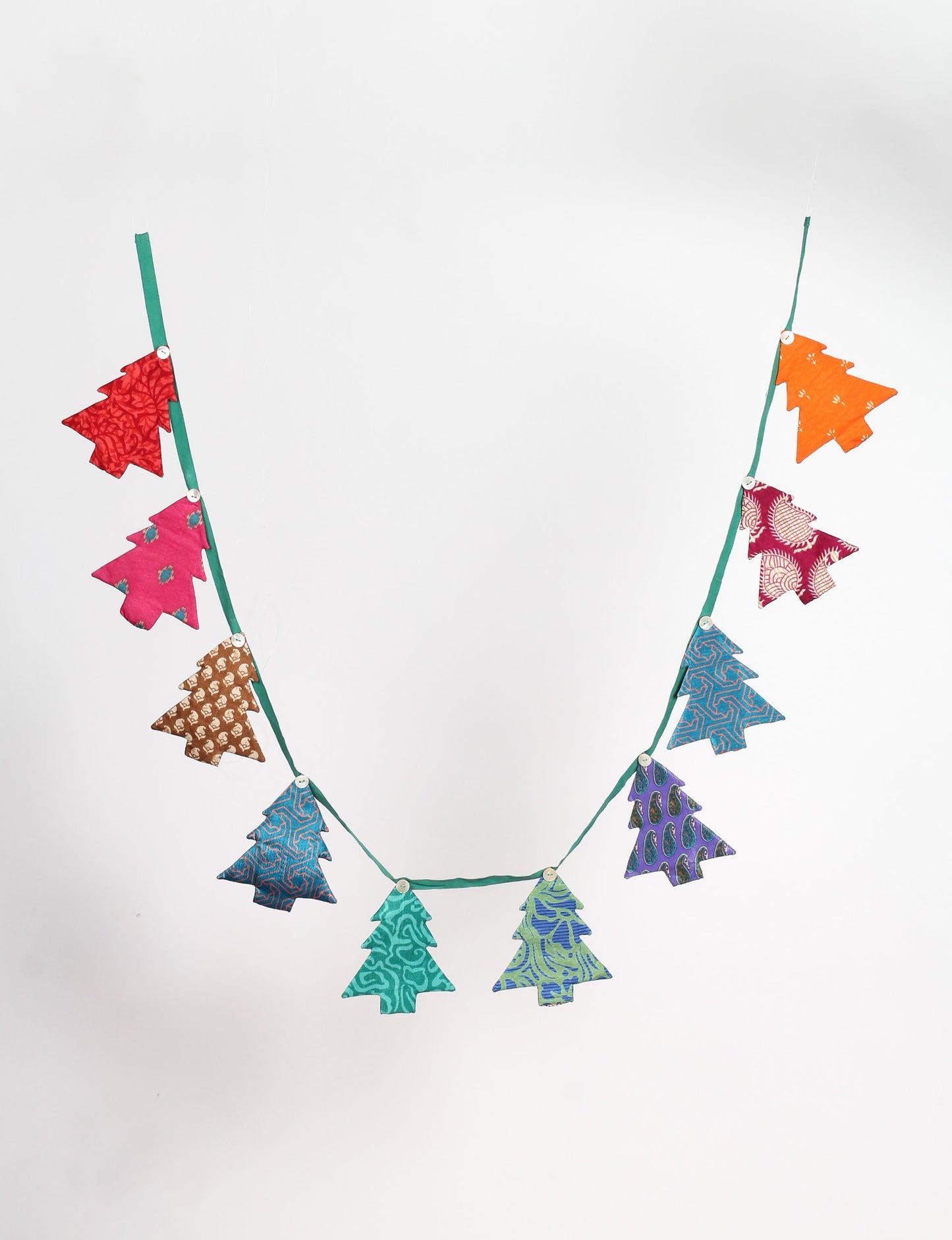 Eco-friendly Christmas bunting featuring Christmas tree patches made from recycled saris, attached to canvas lace with buttons. A sustainable, upcycled decoration promoting circular fashion and ethical holiday decor.