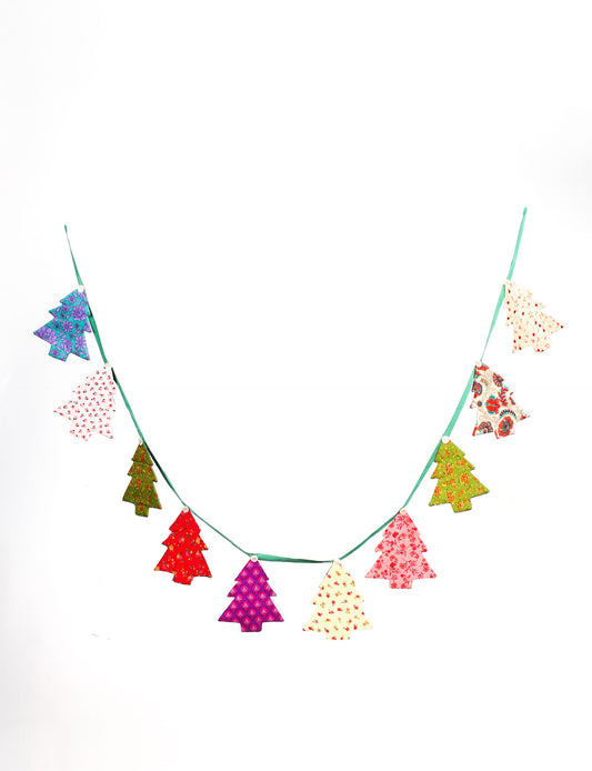 Eco-friendly Christmas bunting featuring Christmas tree patches made from recycled saris, attached to canvas lace with buttons. A sustainable, upcycled decoration promoting circular fashion and ethical holiday decor.