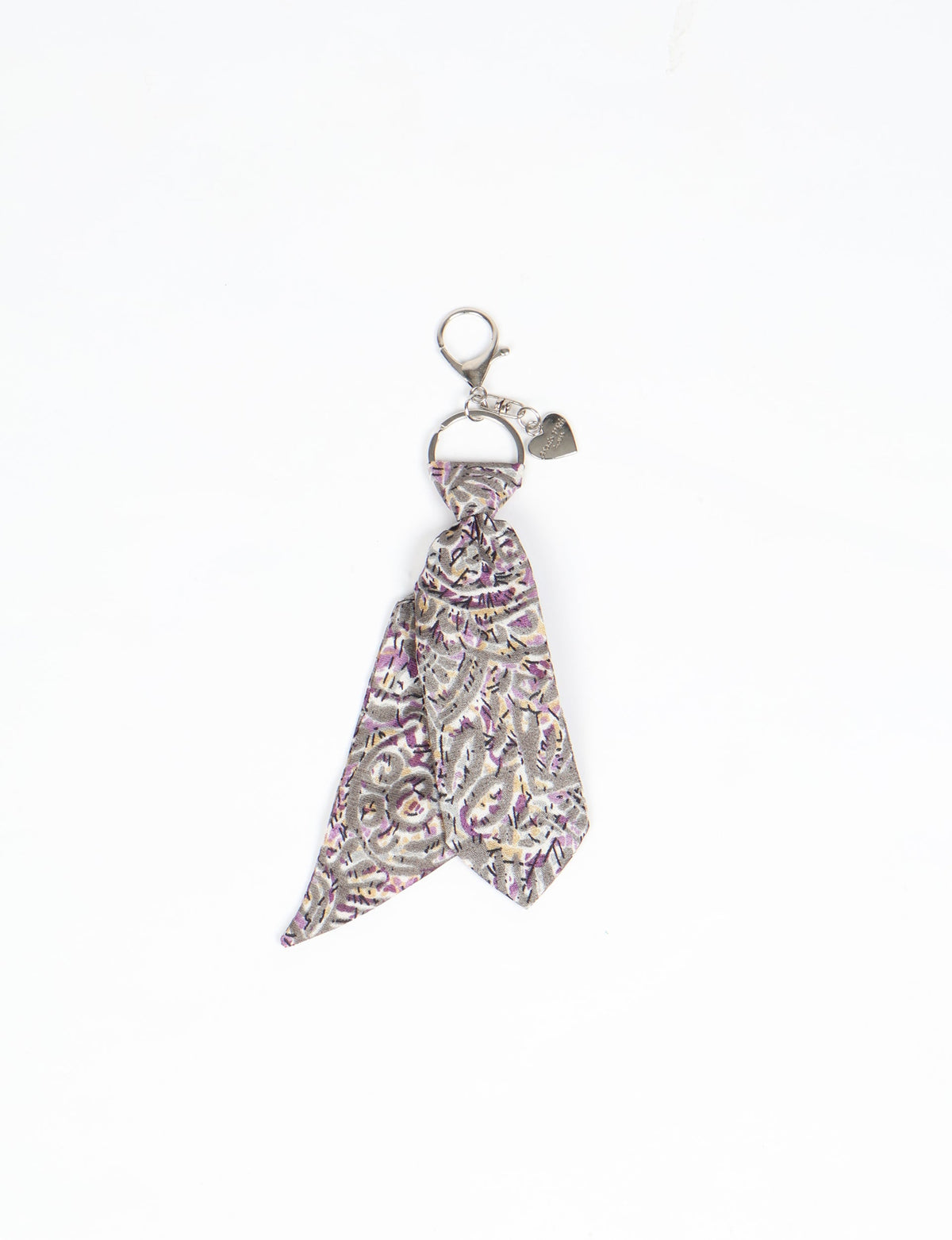 Grey abstract patterned fabric keychain with silver metal ring, lobster clasp, and small heart charm, flat lay on white background