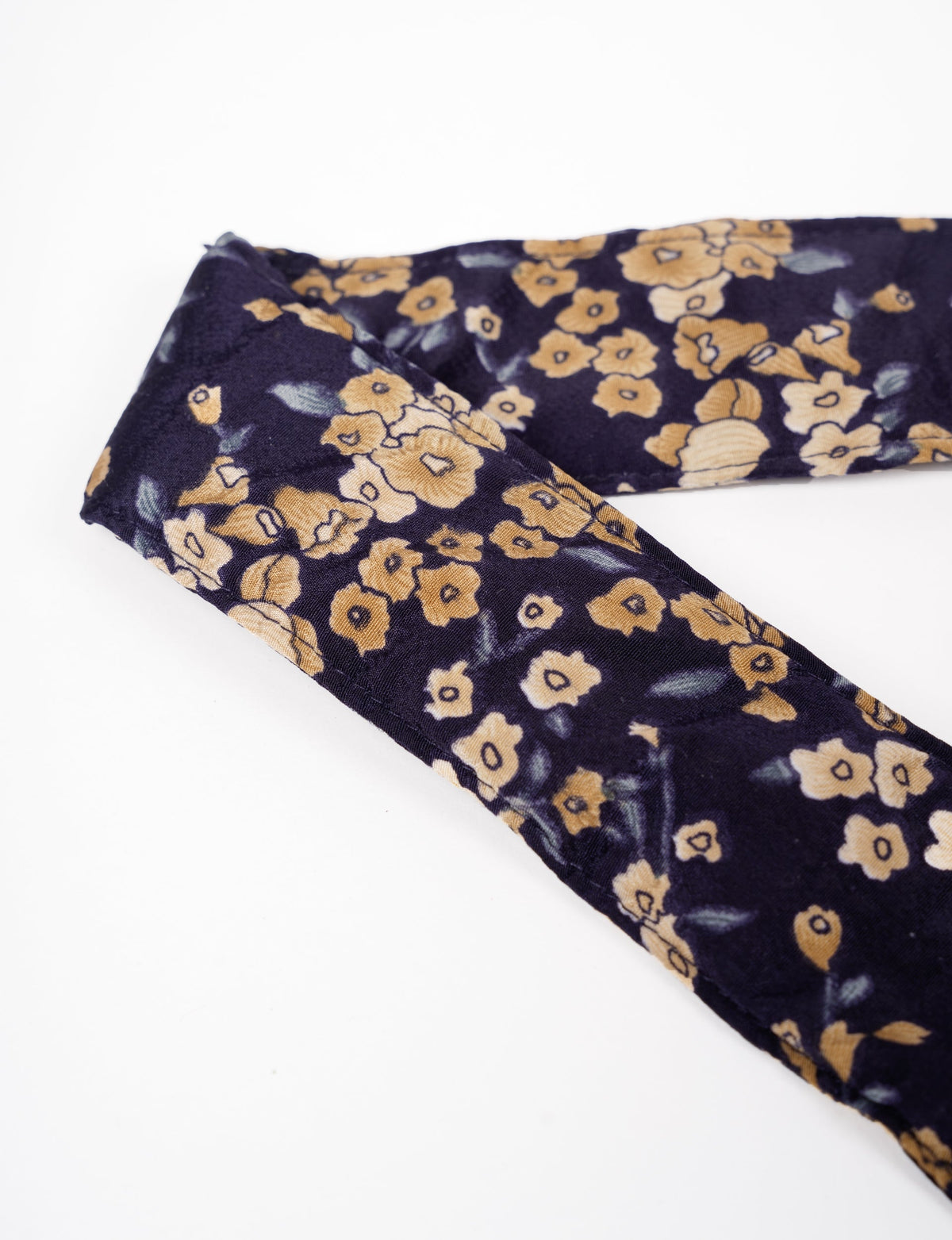 A green yoga mat holder made from upcycled materials, embodying ethical and sustainable fashion ideals.