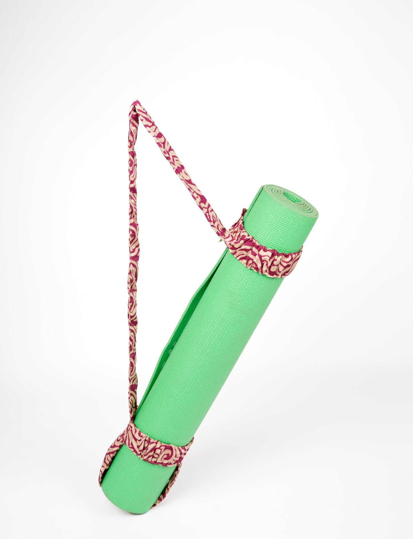 A green yoga mat holder made from upcycled materials, embodying ethical and sustainable fashion ideals.