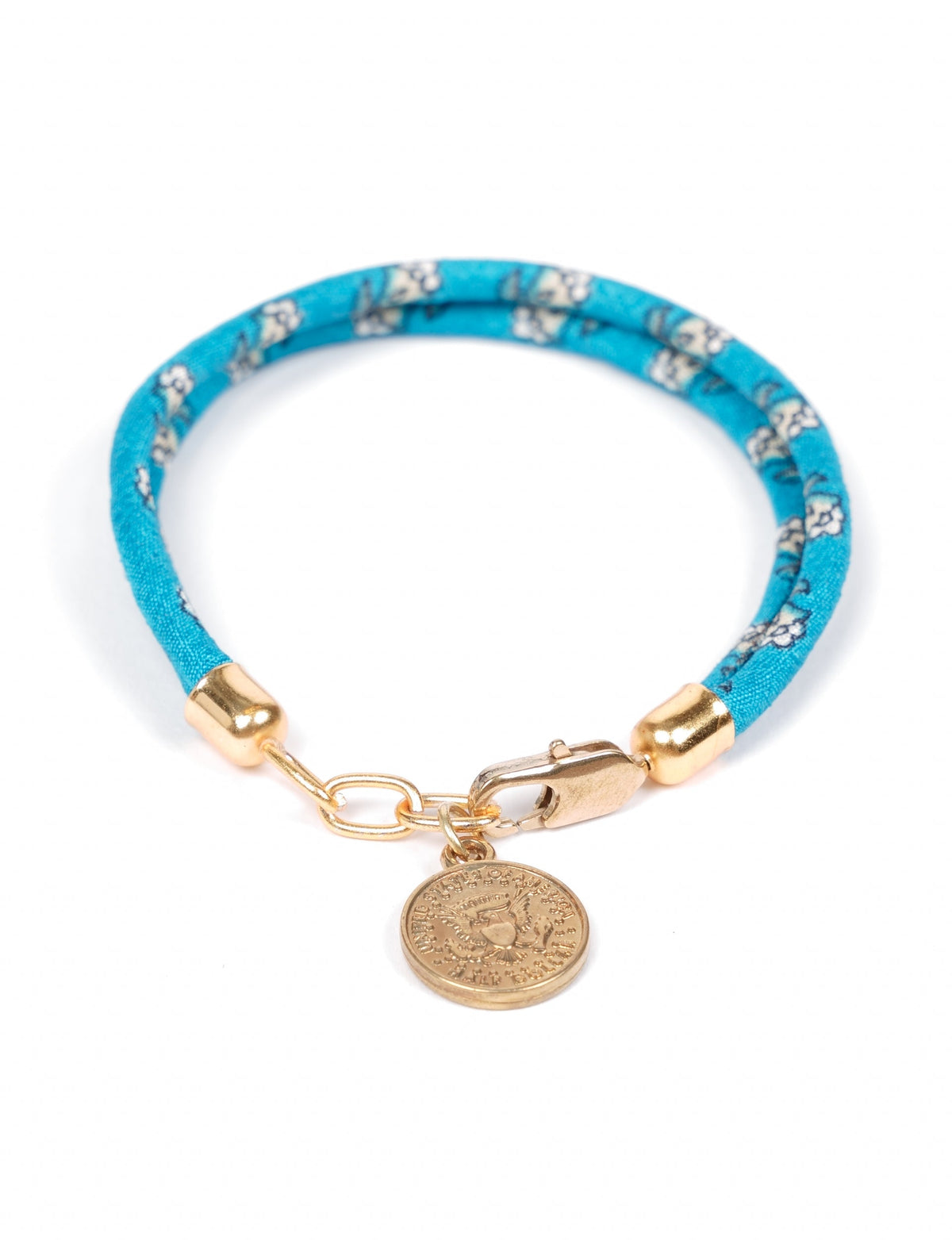 A close-up image of a hand wearing the Sari Rope Bracelete with Charm, showcasing its colorful threads and unique design. This accessory embodies ethical fashion and sustainability, crafted from repurposed saris for a stylish and eco-conscious statement.