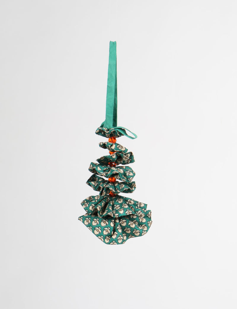 Green fabric Christmas tree ornament with white floral pattern and orange beads, hanging by a green ribbon loop