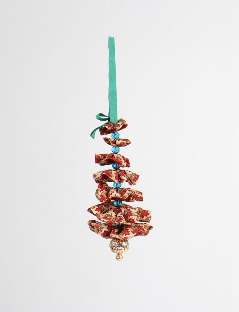 Hanging Christmas tree ornament with red and beige floral fabric layers, blue beads, green ribbon loop, and gold bell at bottom