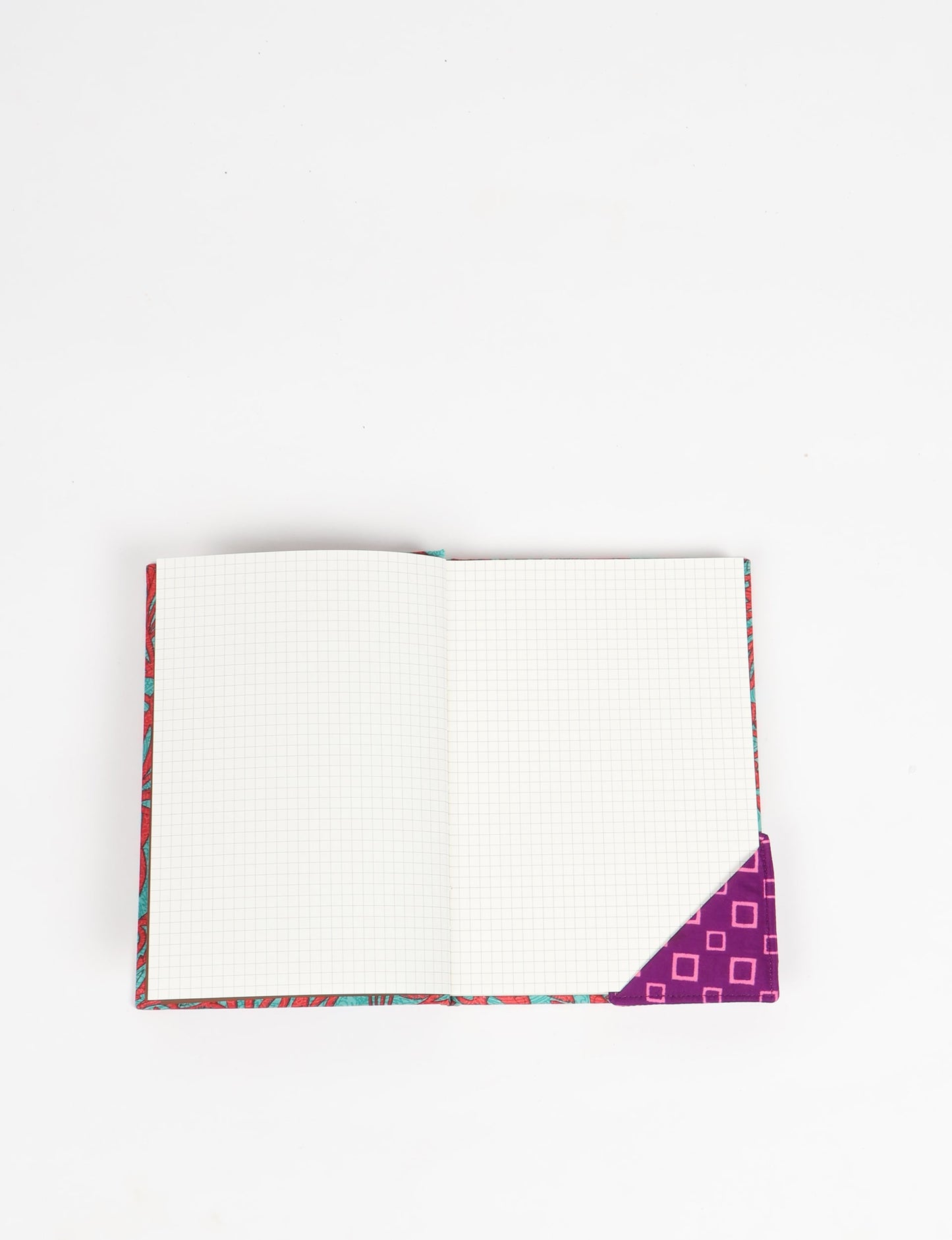 Colorful square-shaped corner bookmark made from recycled sari textiles, representing repurposed clothing, fair trade fashion, and ethical fashion. An earth-friendly product made from textile waste, aligning with carbon neutral clothing values.