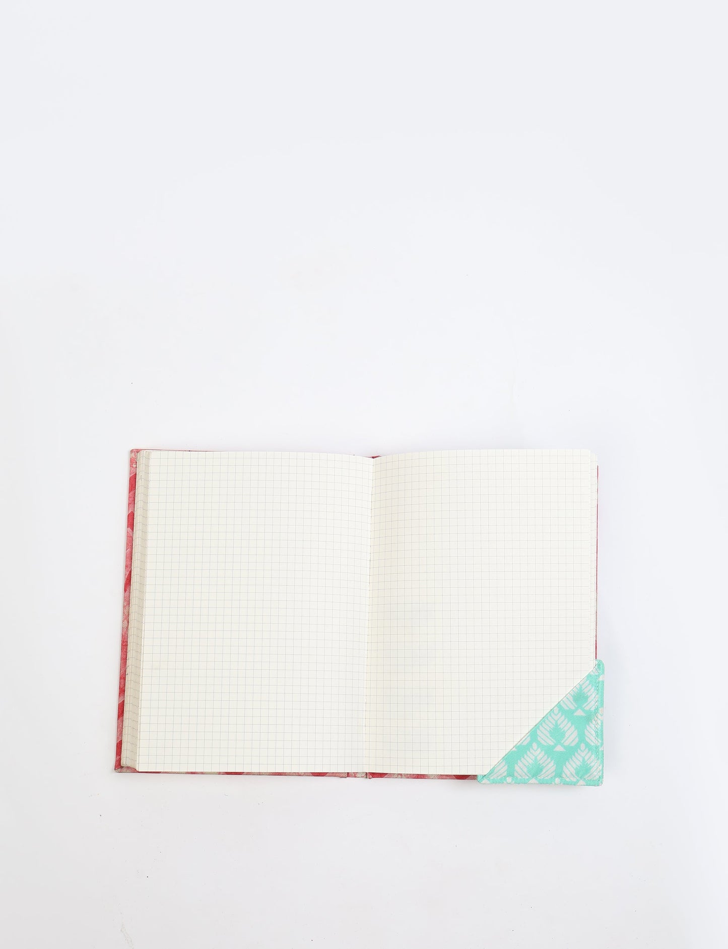 Colorful square-shaped corner bookmark made from recycled sari textiles, representing repurposed clothing, fair trade fashion, and ethical fashion. An earth-friendly product made from textile waste, aligning with carbon neutral clothing values.