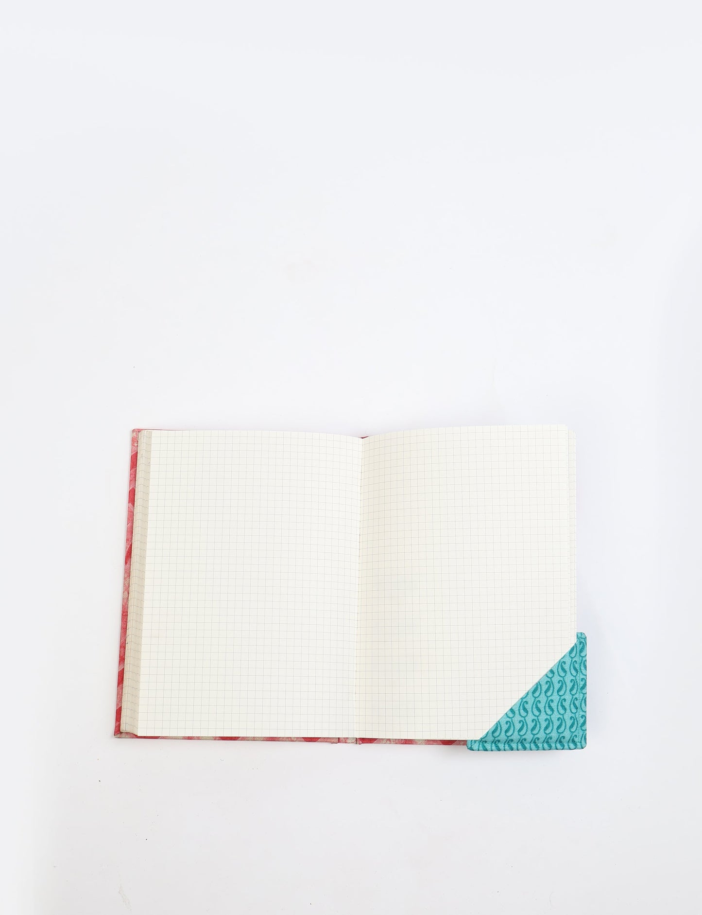 Colorful square-shaped corner bookmark made from recycled sari textiles, representing repurposed clothing, fair trade fashion, and ethical fashion. An earth-friendly product made from textile waste, aligning with carbon neutral clothing values.