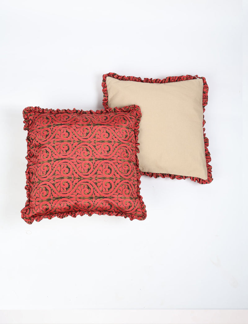 Set of 2 cushion covers with red ethnic swirl pattern and frill border, one front patterned and one plain beige back view