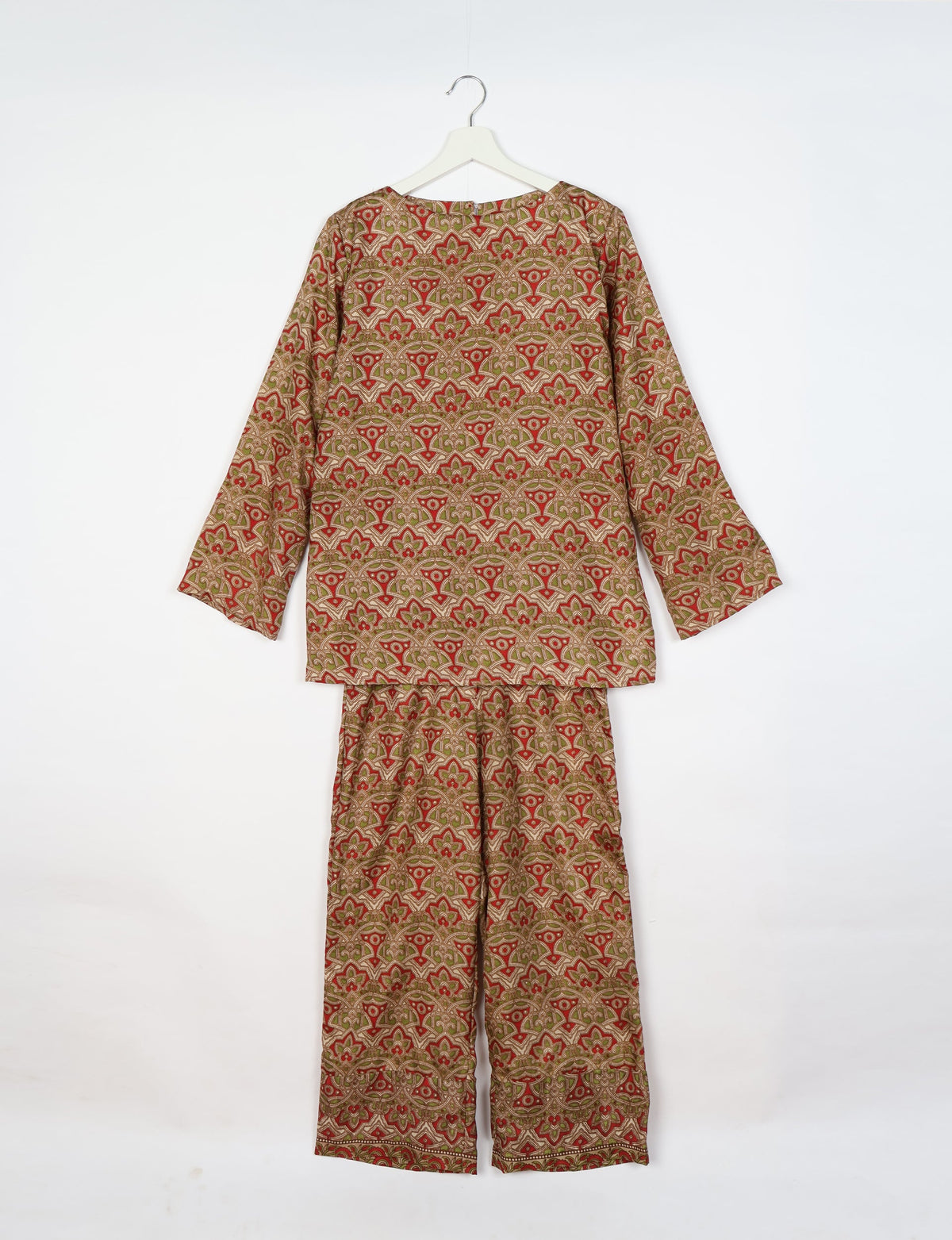 Beige tropical patterned lounge set with long sleeves and wide-leg pants hanging on white hanger against white background