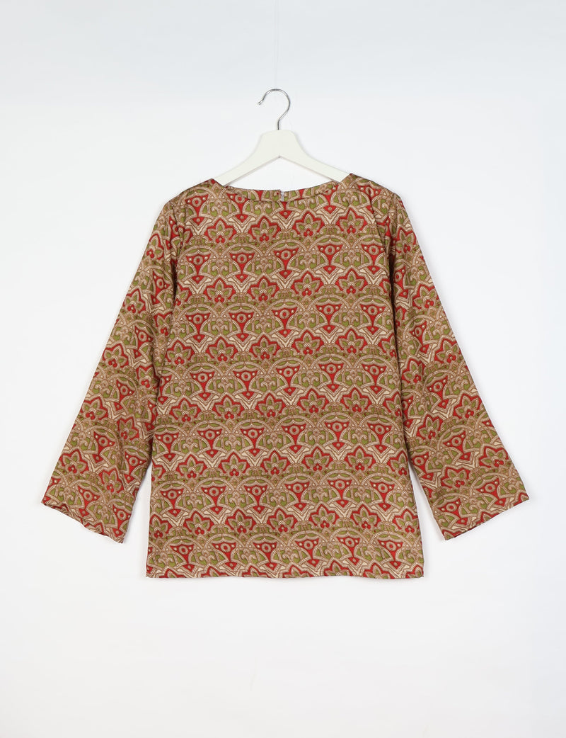 Beige long-sleeve top with red and green tropical floral geometric pattern, round neckline, hanging on white hanger