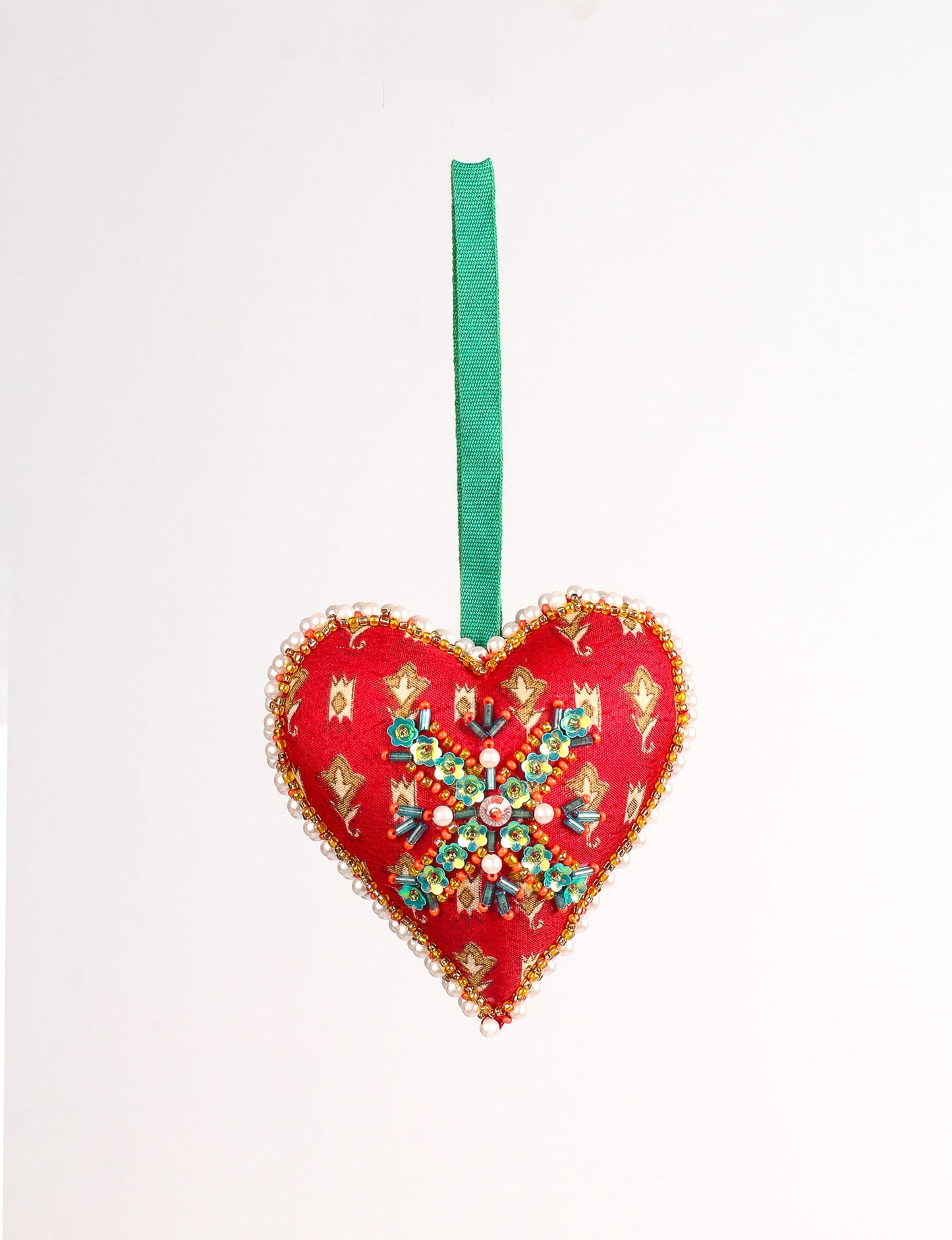 A Christmas heart ornament made from recycled sari fabric, featuring traditional Aari embroidery, representing sustainable, eco-friendly fashion. Handcrafted by artisans, this zero-waste, fair trade product symbolizes recycled material clothing and conscious clothing choices within eco-friendly and circular fashion.