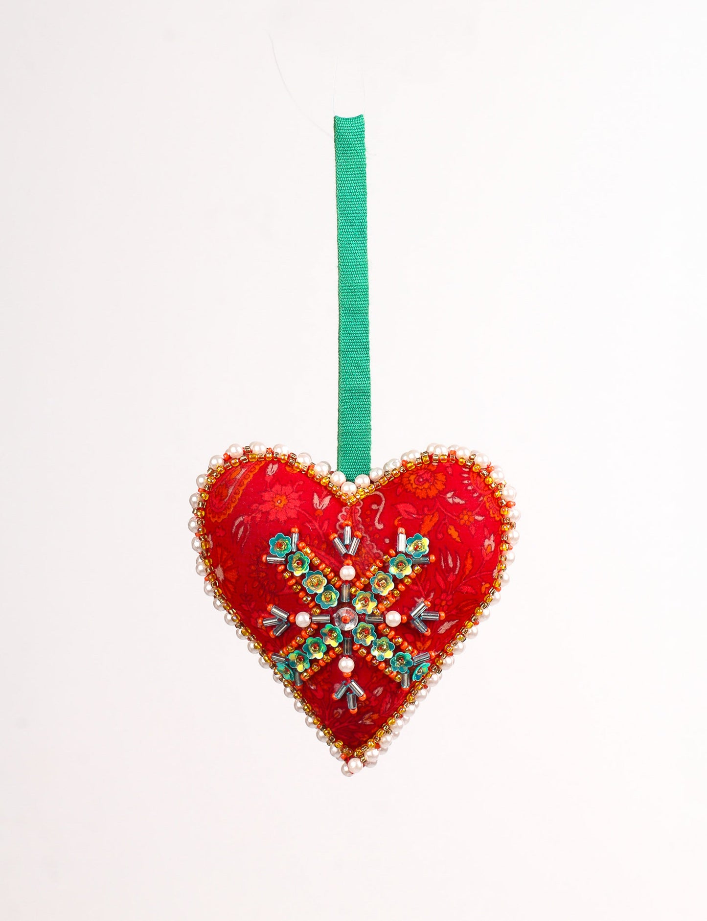 A Christmas heart ornament made from recycled sari fabric, featuring traditional Aari embroidery, representing sustainable, eco-friendly fashion. Handcrafted by artisans, this zero-waste, fair trade product symbolizes recycled material clothing and conscious clothing choices within eco-friendly and circular fashion.