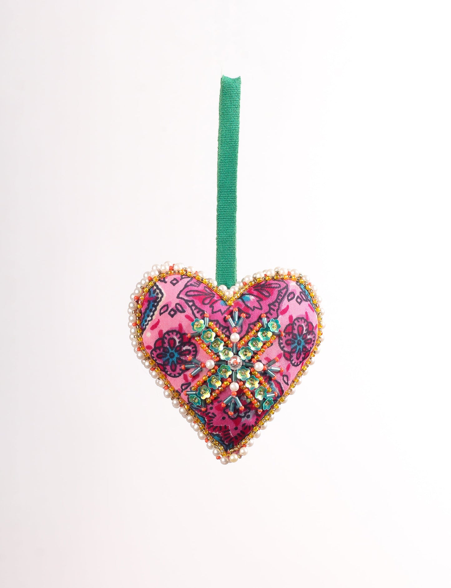 A Christmas heart ornament made from recycled sari fabric, featuring traditional Aari embroidery, representing sustainable, eco-friendly fashion. Handcrafted by artisans, this zero-waste, fair trade product symbolizes recycled material clothing and conscious clothing choices within eco-friendly and circular fashion.