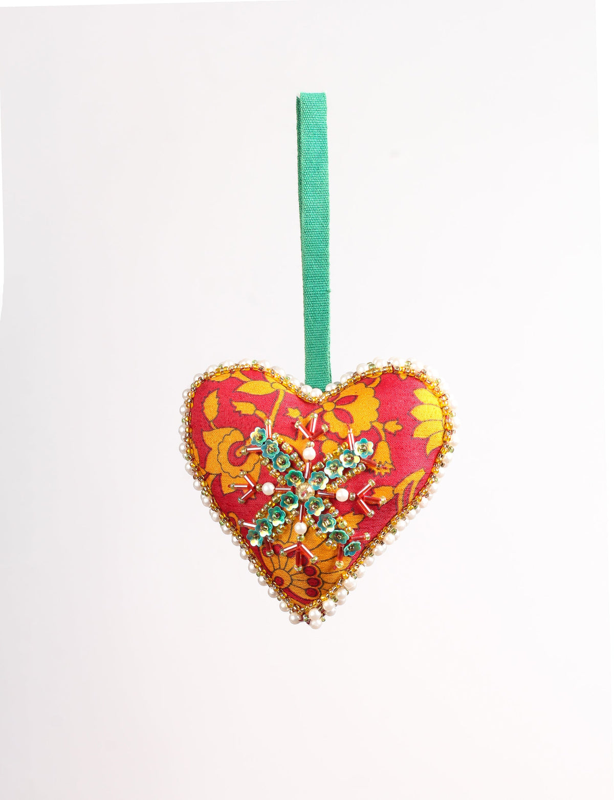 Red heart-shaped fabric ornament with yellow floral pattern, green beaded snowflake, pearl and gold bead trim, and green