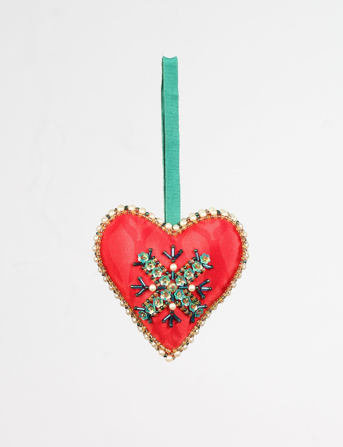 Red heart-shaped ornament with green and pearl bead snowflake design, gold bead trim, and green hanging ribbon