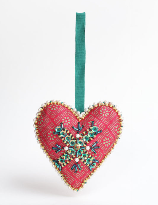 A Christmas heart ornament made from recycled sari fabric, featuring traditional Aari embroidery, representing sustainable, eco-friendly fashion. Handcrafted by artisans, this zero-waste, fair trade product symbolizes recycled material clothing and conscious clothing choices within eco-friendly and circular fashion.