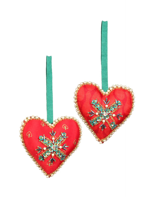 A Christmas heart ornament made from recycled sari fabric, featuring traditional Aari embroidery, representing sustainable, eco-friendly fashion. Handcrafted by artisans, this zero-waste, fair trade product symbolizes recycled material clothing and conscious clothing choices within eco-friendly and circular fashion.