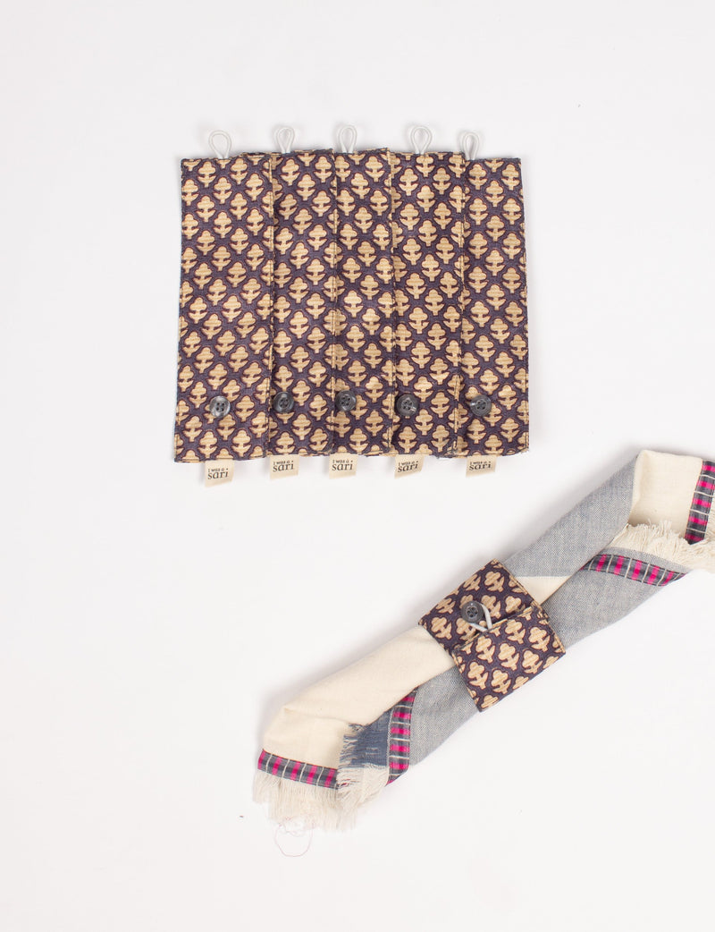 Set of six brown napkin rings with beige micro leaf pattern, button closure, and fabric loop, shown flat with a rolled napkin