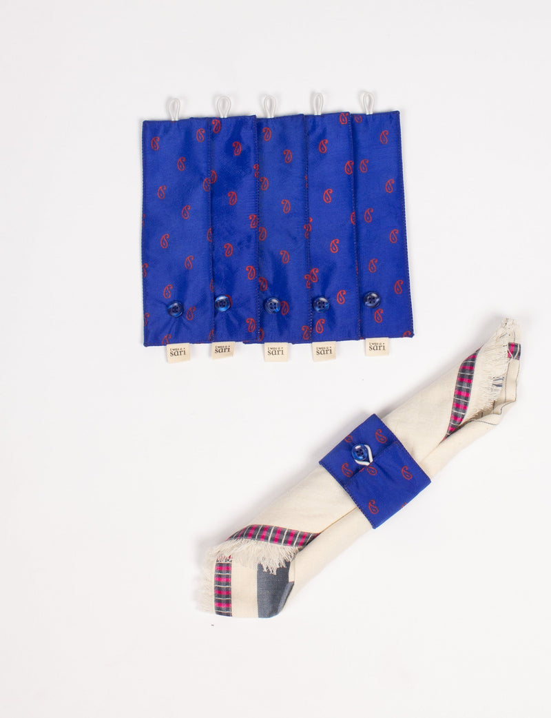 Set of six blue fabric napkin rings with red paisley print, each with a button and loop closure, shown flat and on a rolled napkin