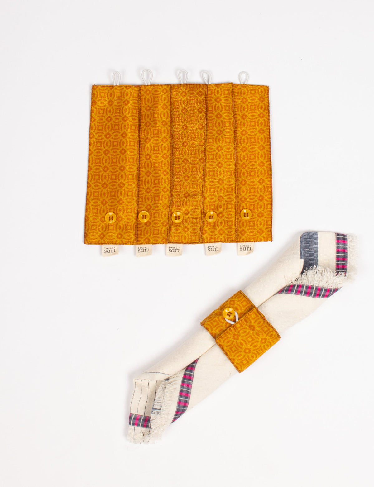 Set of six orange patterned fabric napkin rings with buttons and "I was a sari" tags, shown flat and on a rolled napkin