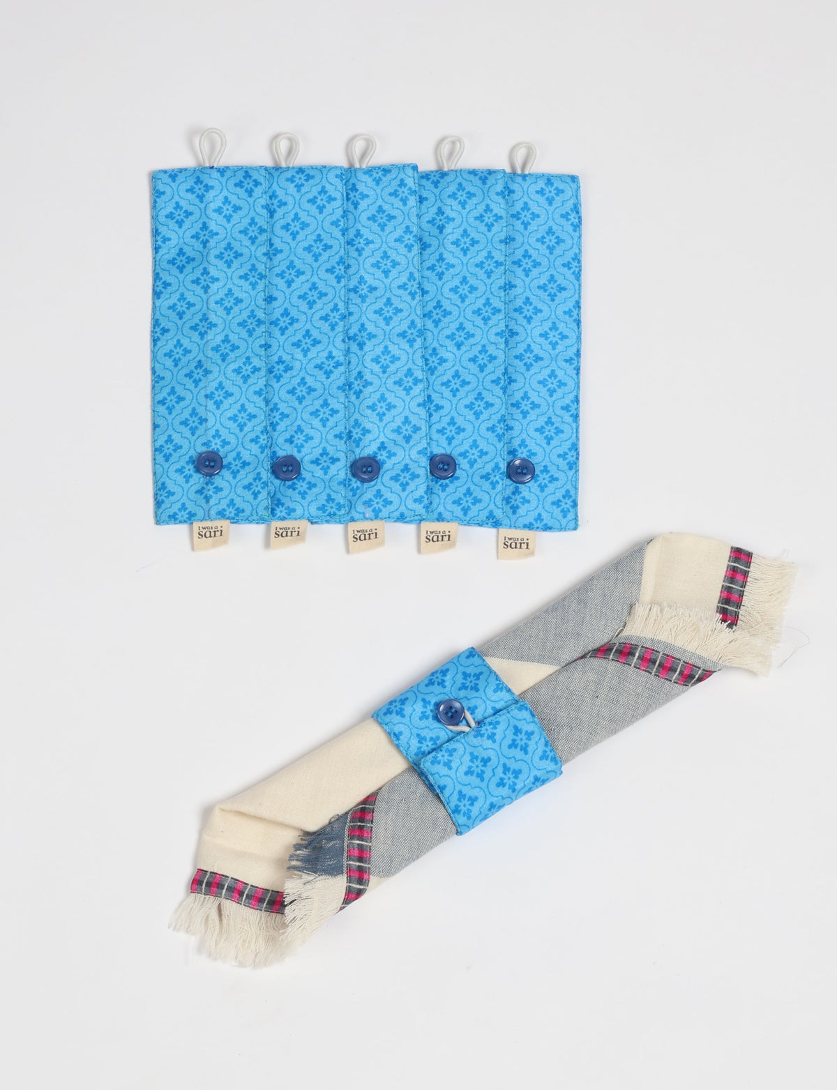 Set of 6 blue fabric napkin rings with floral pattern and button closure, shown flat and wrapped on a napkin