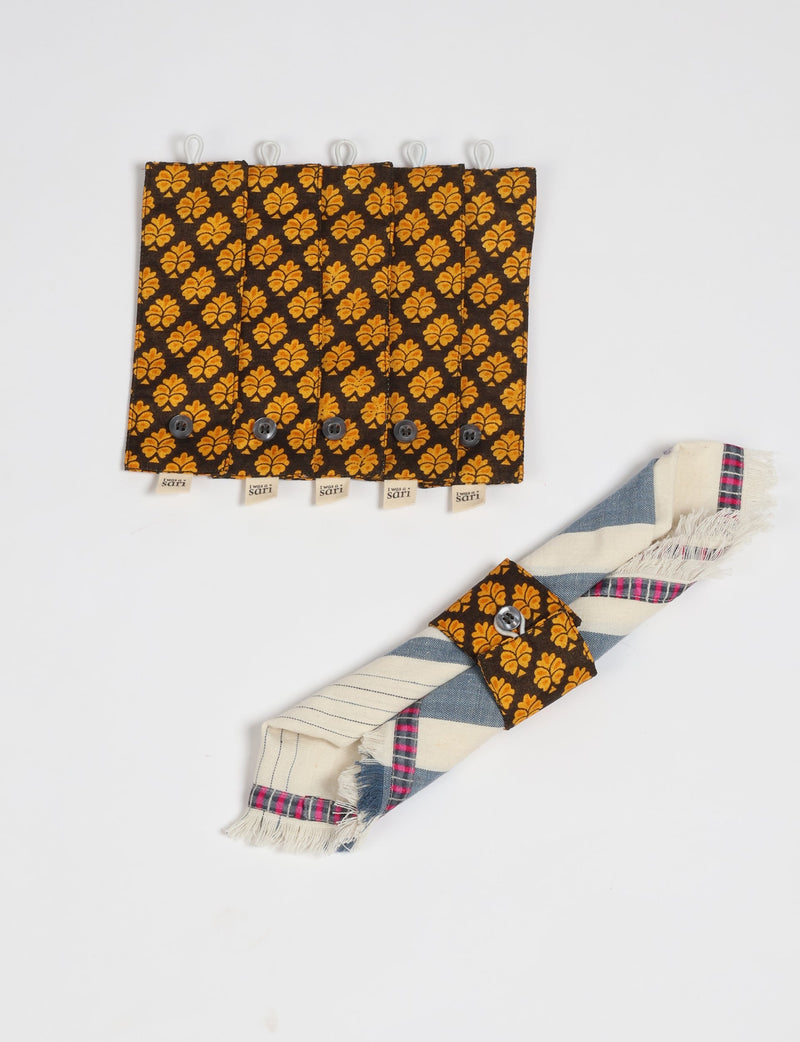 Set of 6 brown and orange patterned fabric napkin rings with button closures, one shown securing a striped cloth napkin