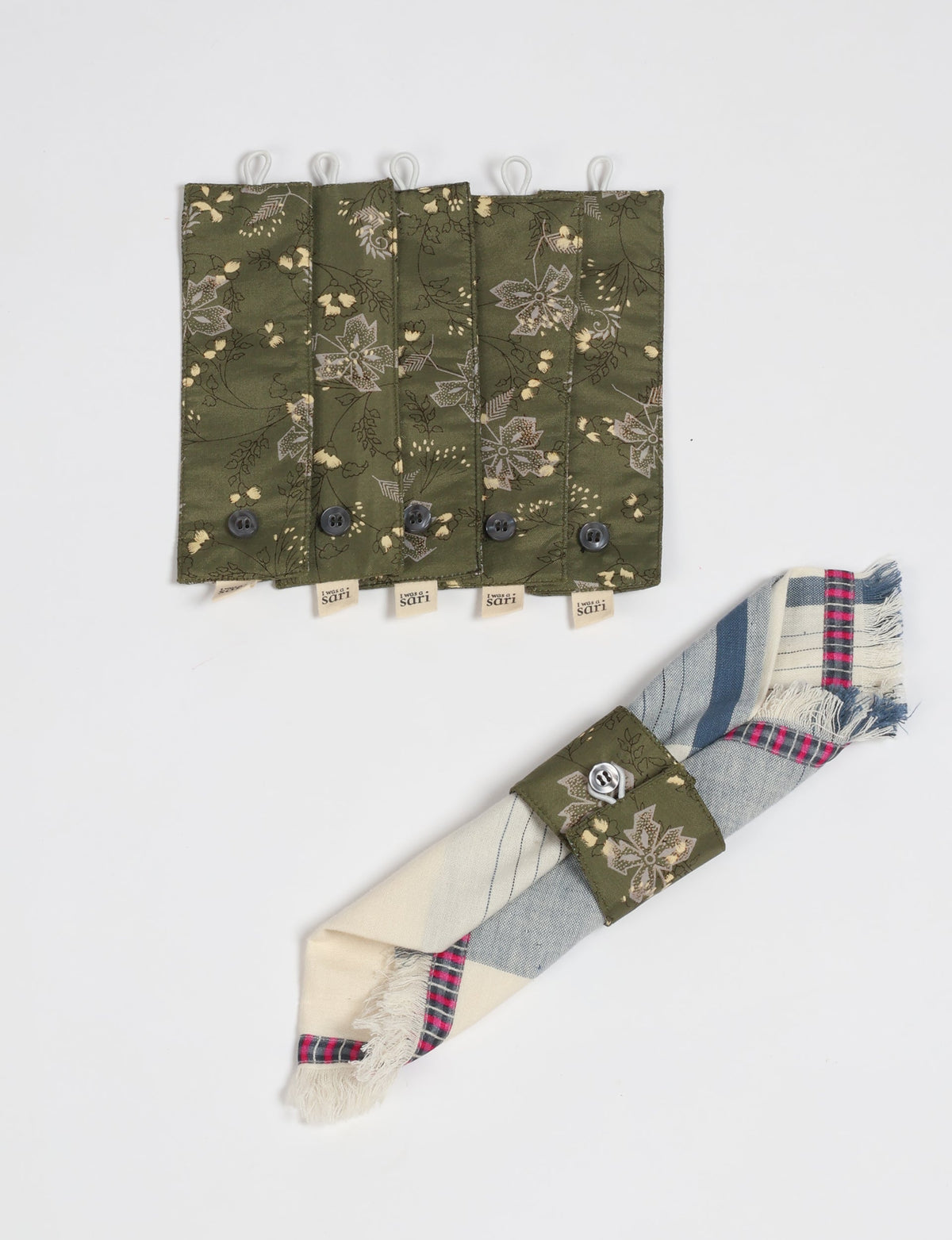 Set of six olive green fabric napkin rings with floral print and button closures, shown flat and on a folded napkin