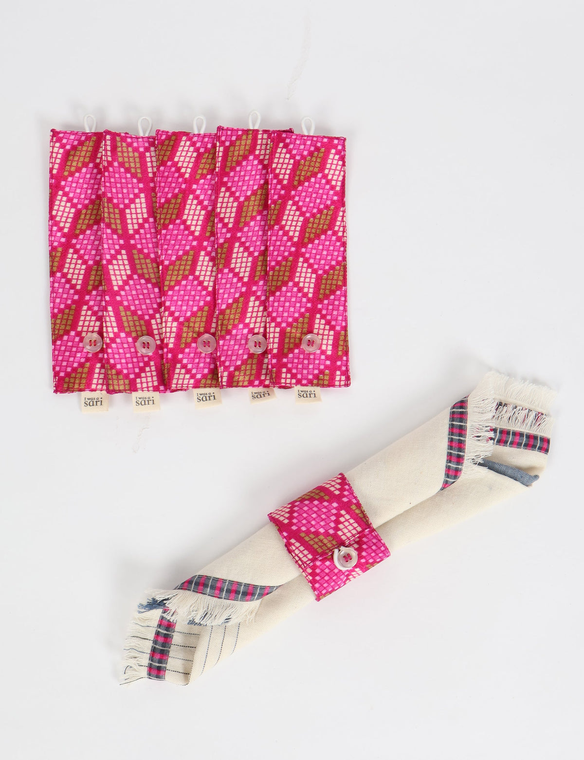 Set of six pink geometric patterned fabric napkin rings with button closures, shown flat and one wrapped around a napkin